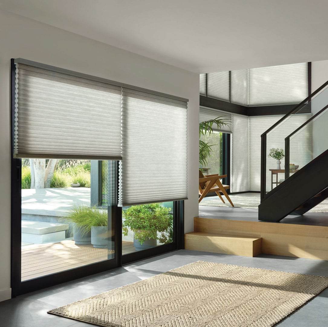 Cellular shades filtering in natural light into a sleek living room.