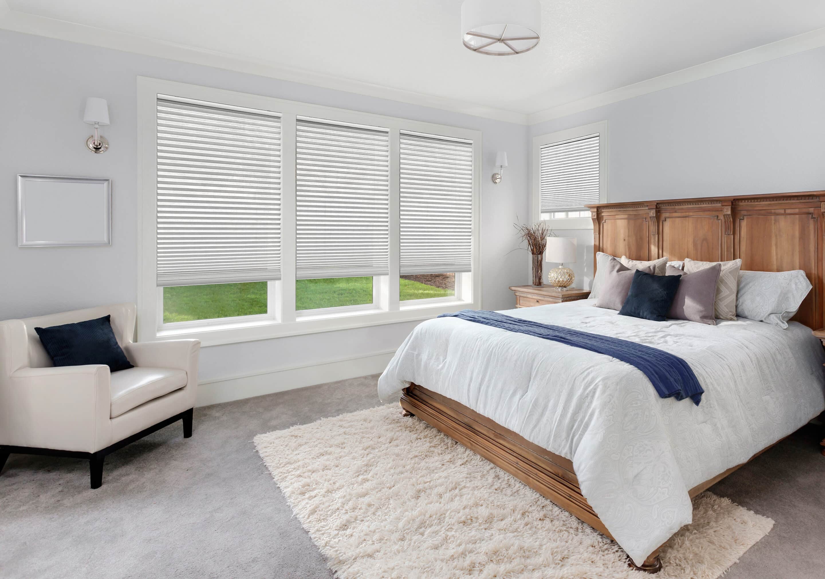 Cellular shades filtering in natural light into a beautiful master bedroom.